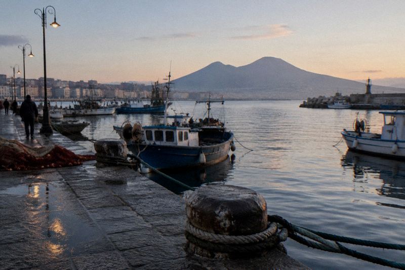 Naples waterfront promenade on the Bay of Naples with Castel dell'Ovo and Mount Vesuvius behind in early morning
