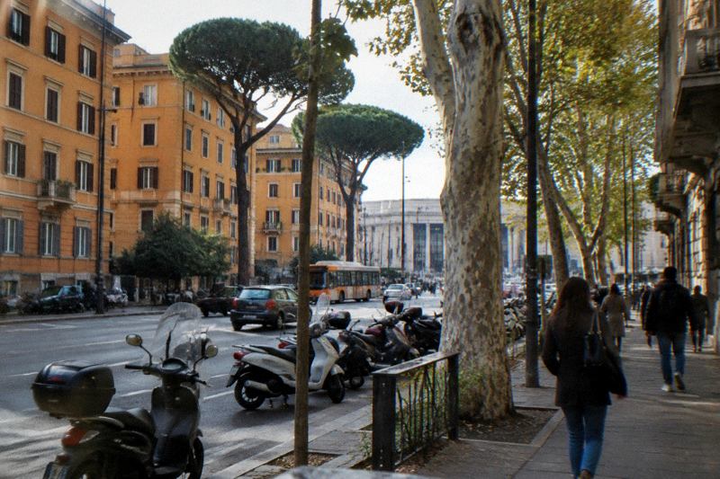 Rome Termini station area at morning with a coach pickup street and ordinary city traffic, no signs readable