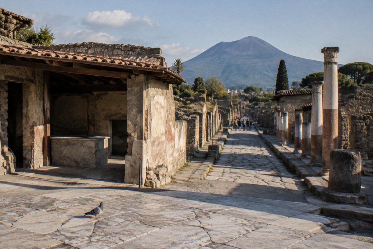 Herculaneum excavated Roman street with roofed houses and Vesuvius rising behind the ruins