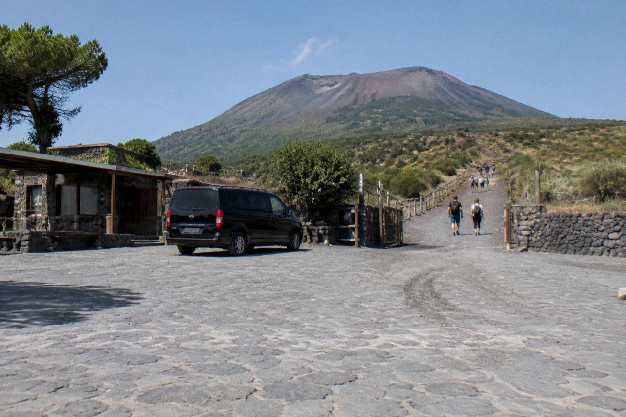 Small private minivan parked at the Quota 1000 car park on Vesuvius with the Gran Cono trail beginning behind it
