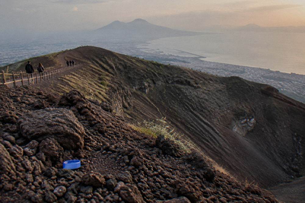 Wide view from the Vesuvius crater rim across the Bay of Naples toward distant coastline towns