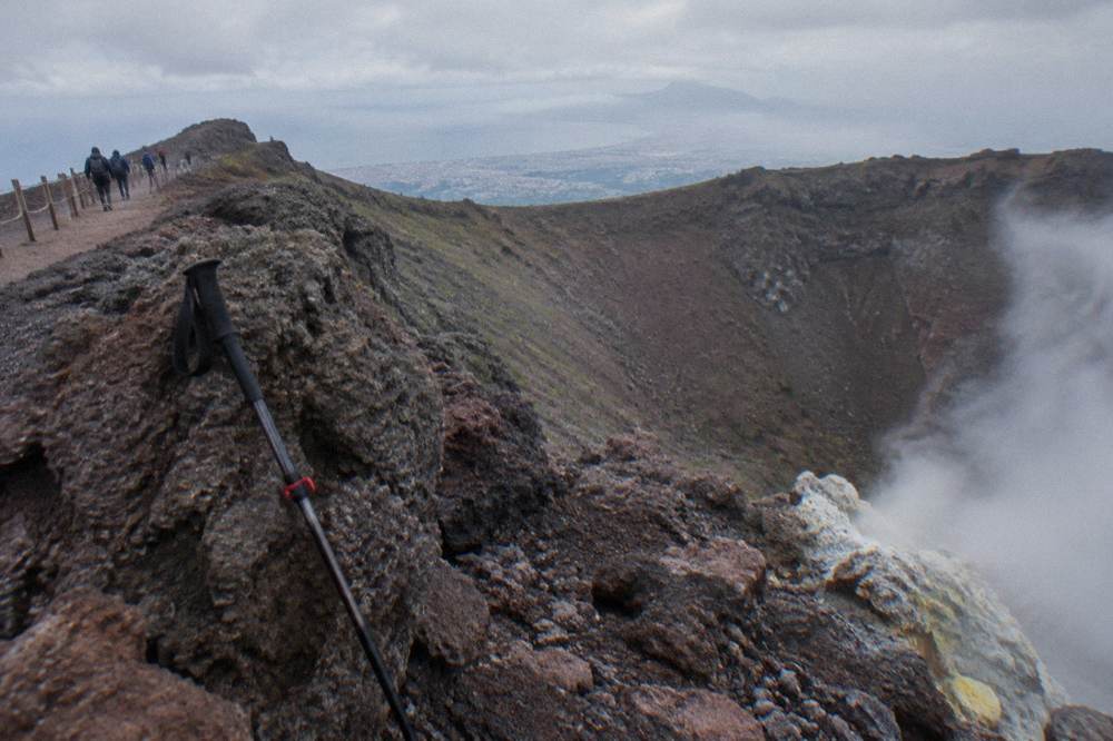 Crater rim of Vesuvius with fumarole steam rising from dark volcanic rock