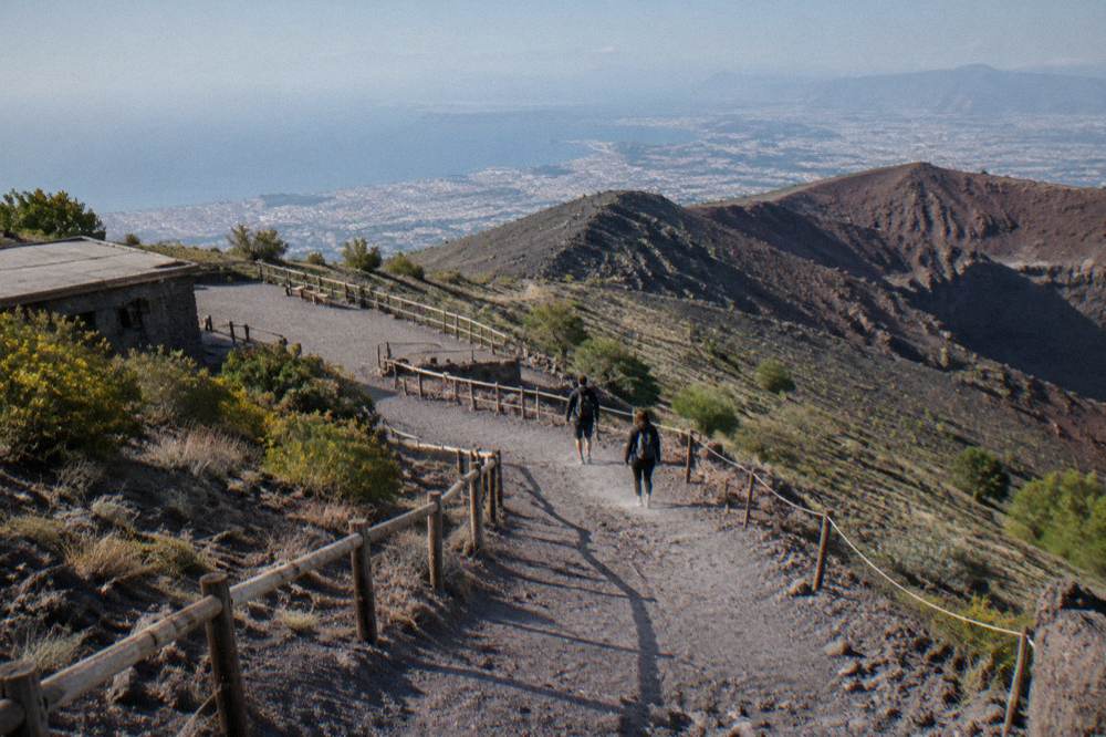 Walkers in sturdy shoes on the dusty switchback path toward the Vesuvius crater rim