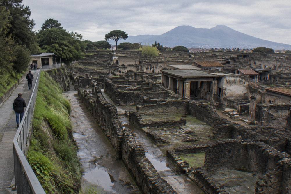 Rows of stone foundations and wall fragments stretching along an ancient excavated street