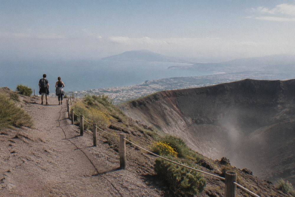 Visitors on the crater rim path of Vesuvius looking out over the Bay of Naples toward Sorrento
