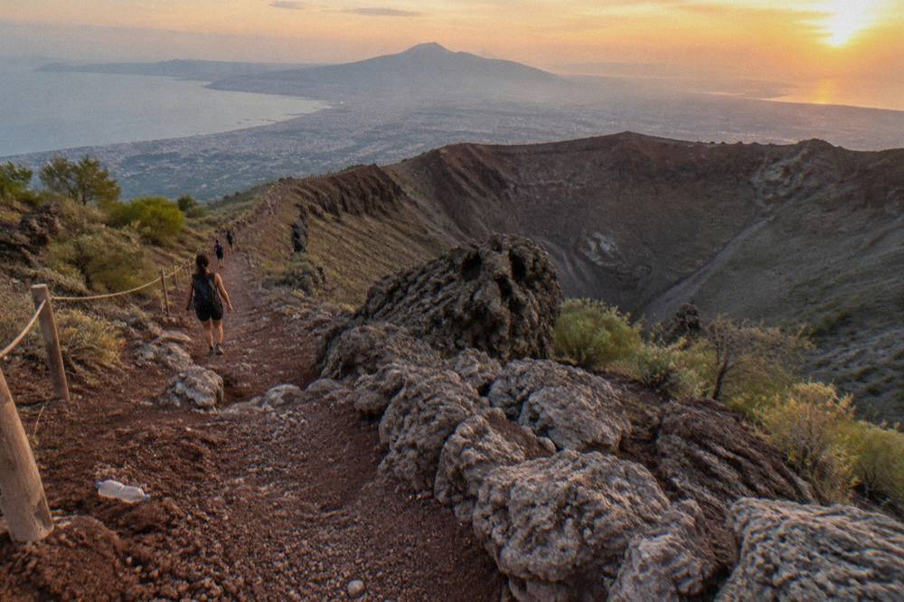 A dirt footpath climbing through loose volcanic scoria toward the crater edge