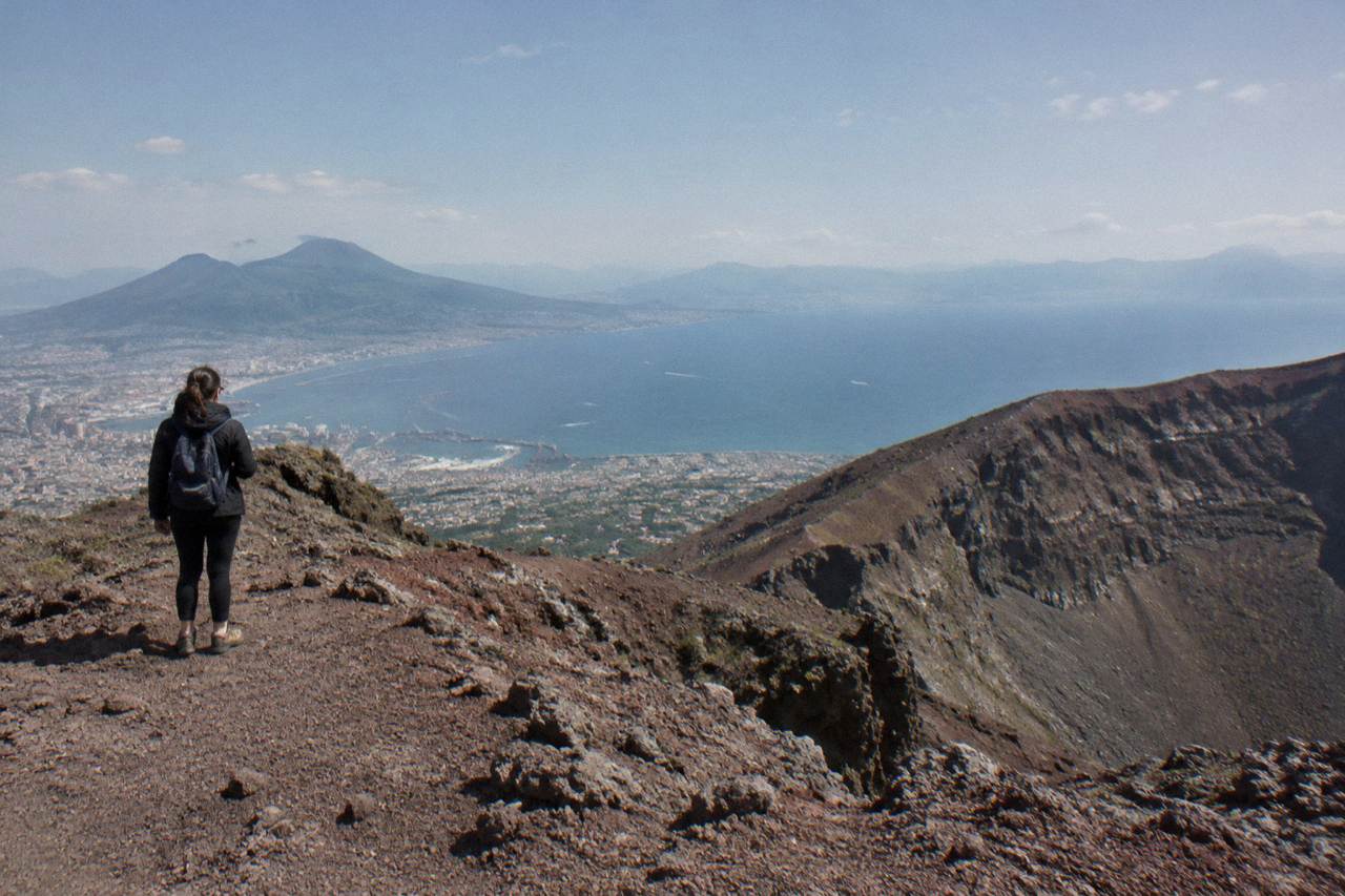 The crater rim of Mount Vesuvius under a wide sky above the Bay of Naples