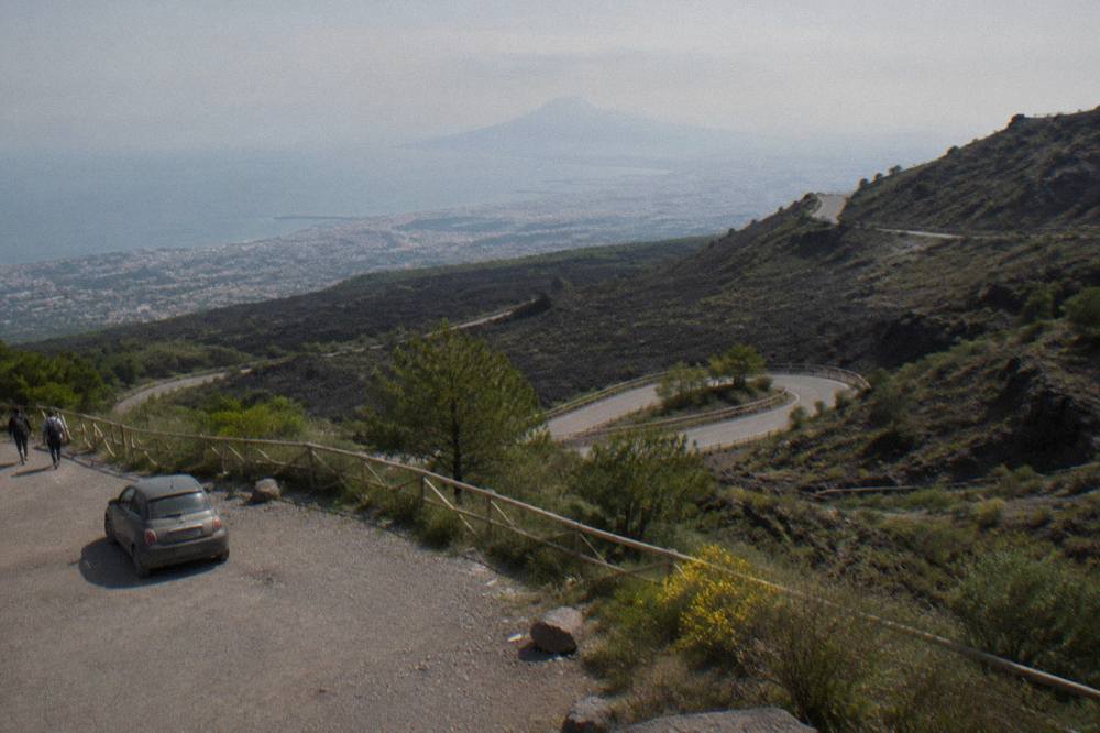 The switchback access road climbing the slopes of Vesuvius through scrub and old lava flows