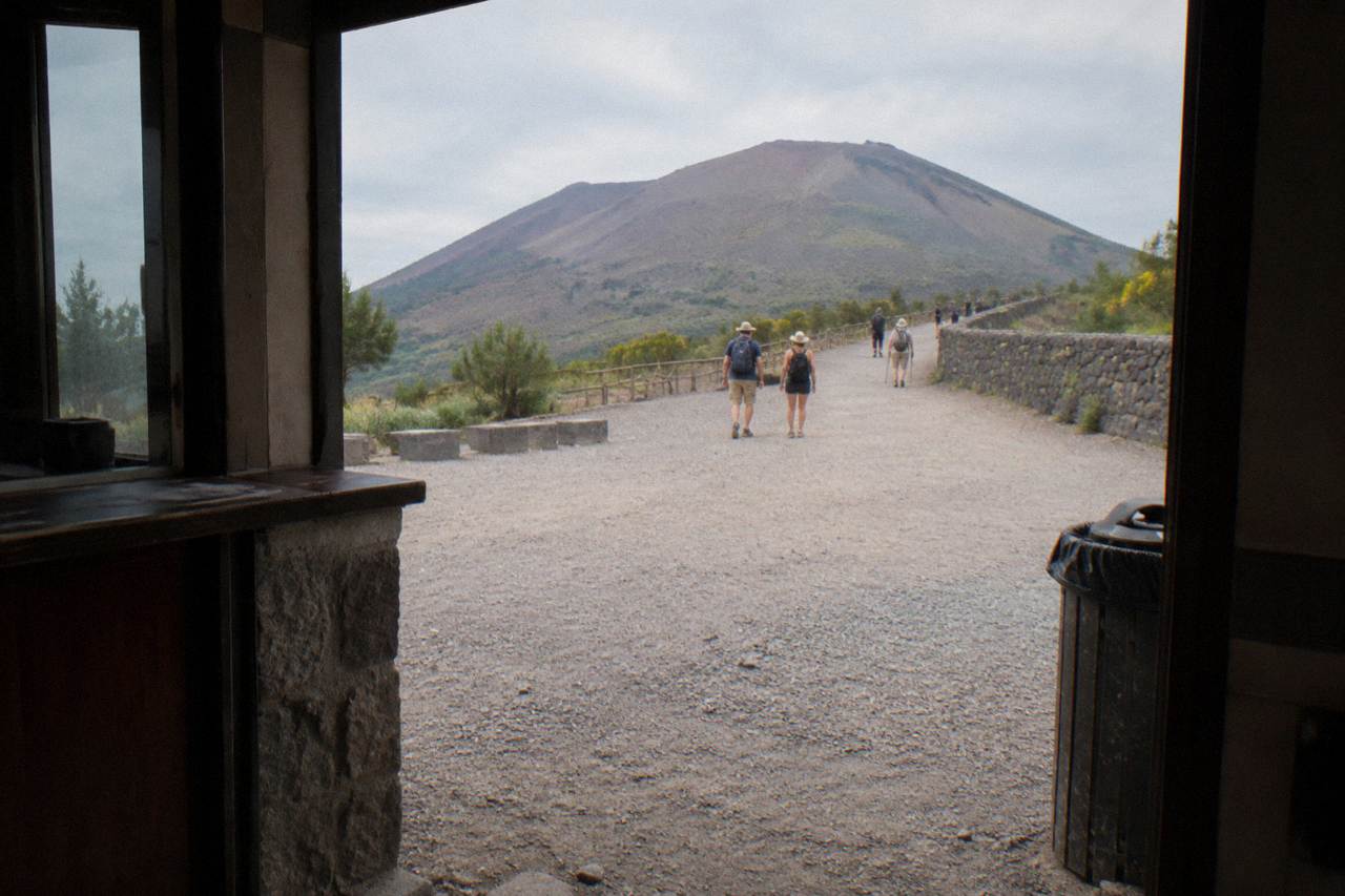 The gravel crater trail of Mount Vesuvius climbing toward the rim under a clear sky