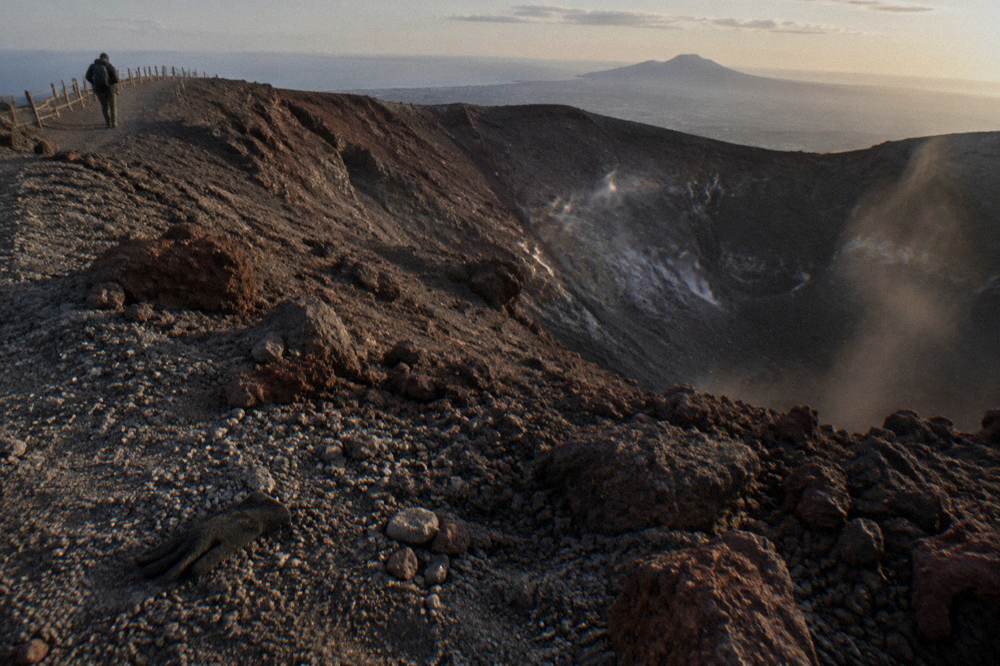 Crater rim of Mount Vesuvius with dark volcanic rock under afternoon light
