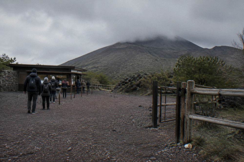 The open rocky plaza at the foot of the Vesuvius crater trail under heavy cloud