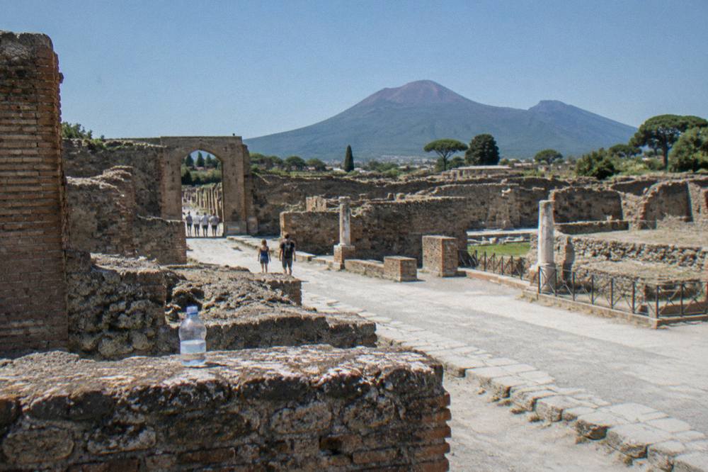 Stone streets and ruined walls of Pompeii under bright sky