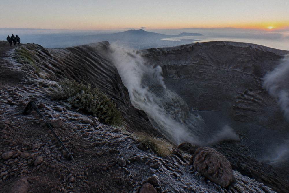 The Mount Vesuvius crater rim with fumarole steam drifting across the rocky inner wall