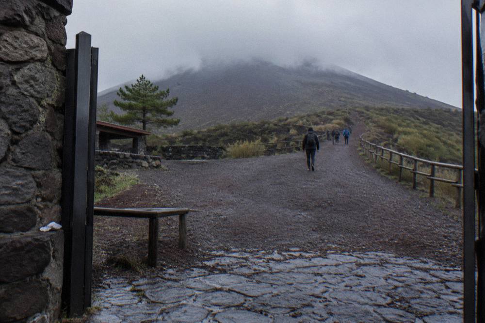 The gravel crater path rising toward the Vesuvius rim with the Bay of Naples below