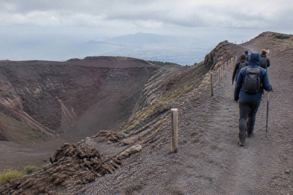 A volcanological guide leading a small walking group along the crater path