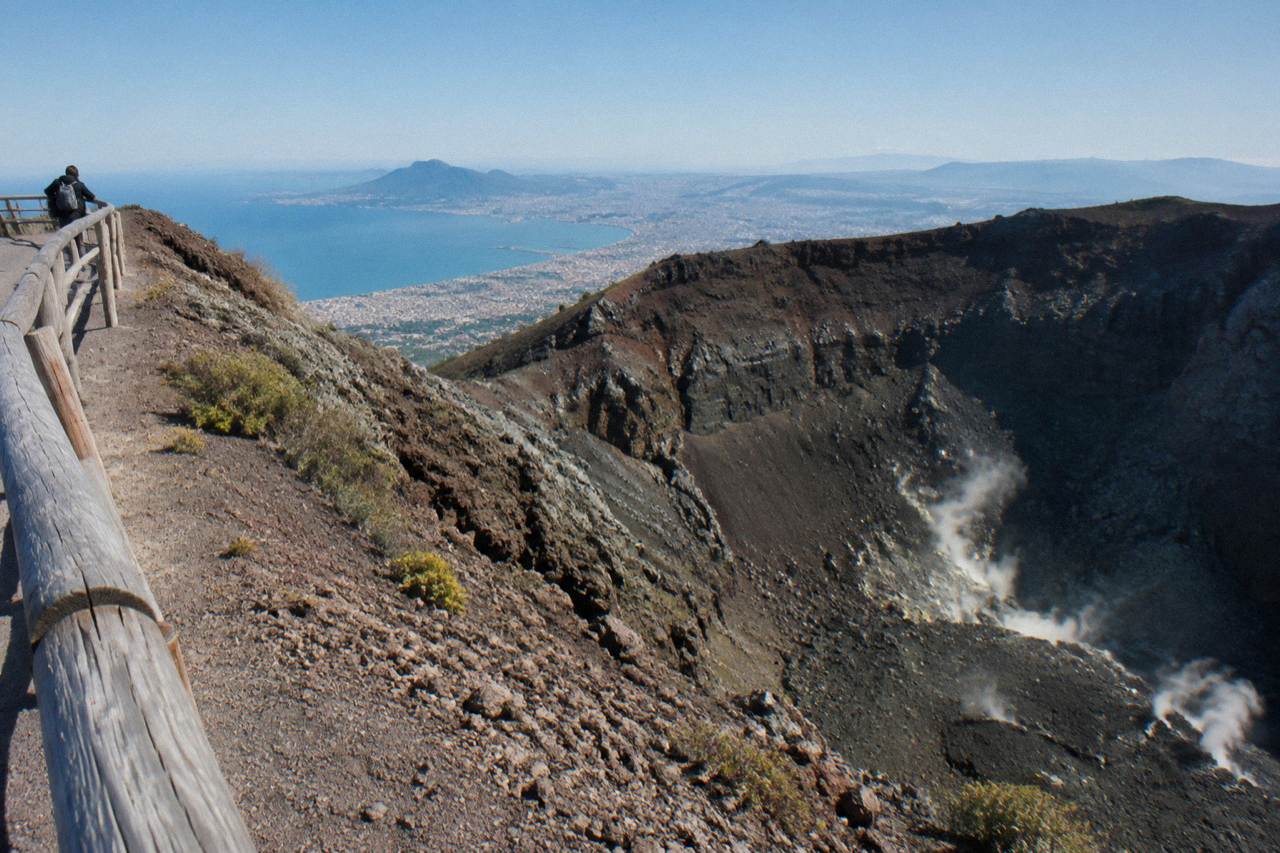 The Vesuvius crater rim under a clear sky with the Bay of Naples in the distance