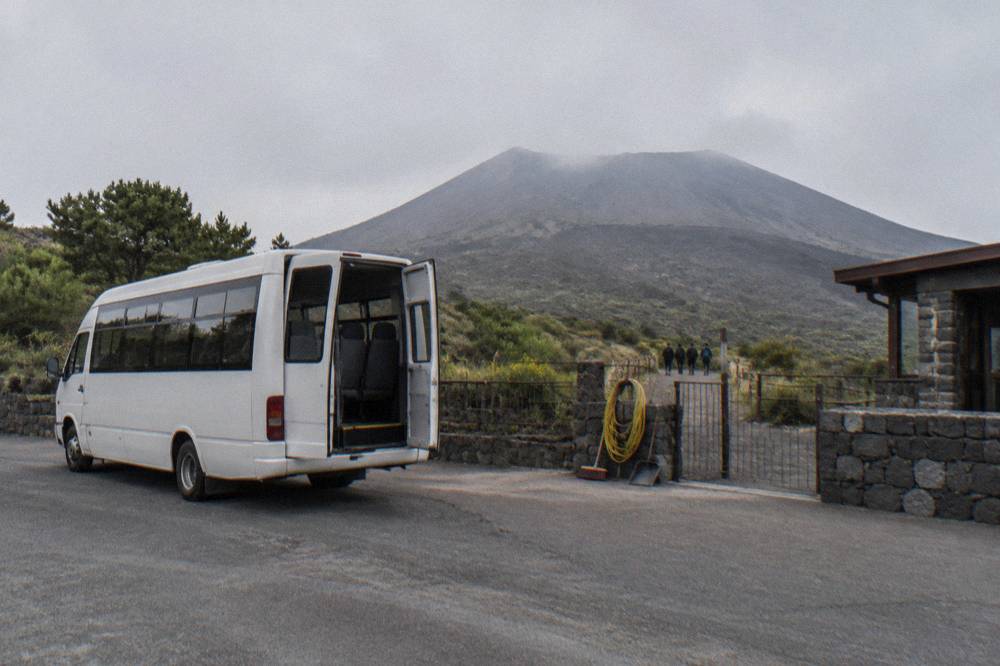 A shuttle bus parked at the Quota 1000 plaza below the Vesuvius crater path