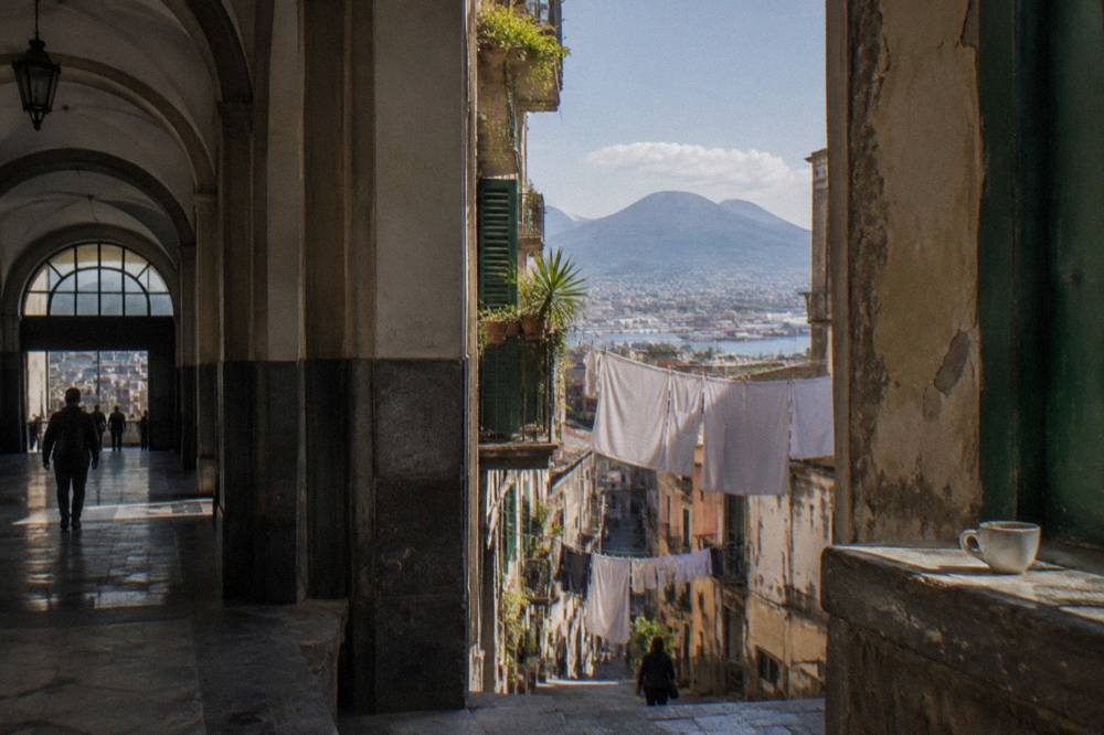 A sunlit alley in the Naples historic centre with laundry strung between tall old buildings