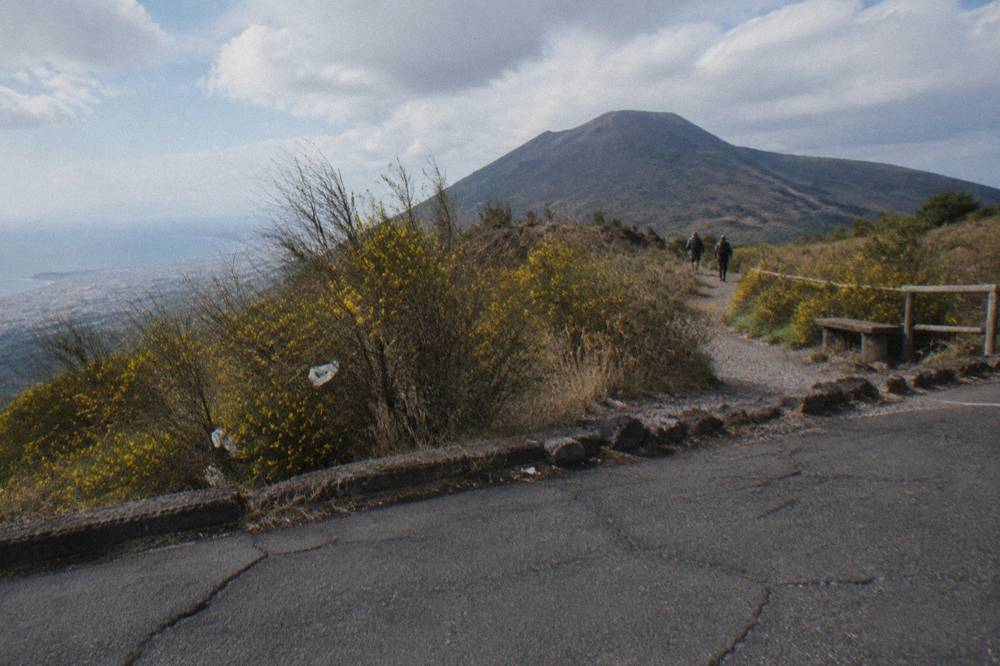 A wide gravel path rising through scrub toward the volcanic cone under an open sky