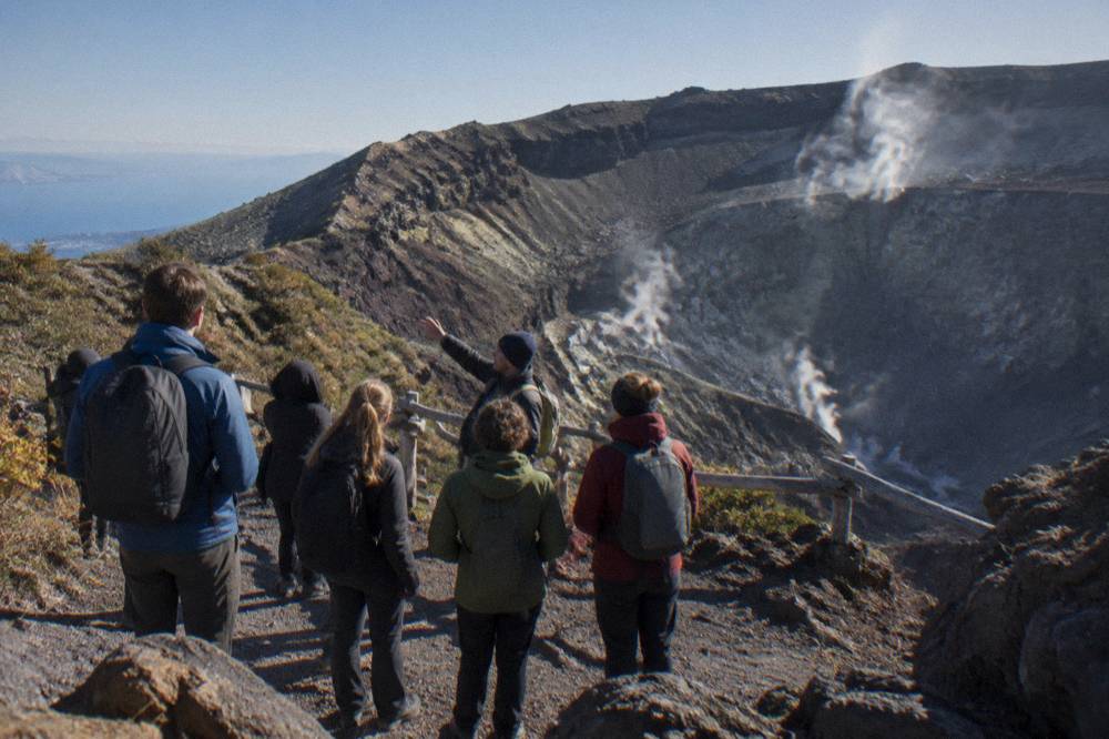 A park guide speaking to a small group of hikers on the Vesuvius crater rim