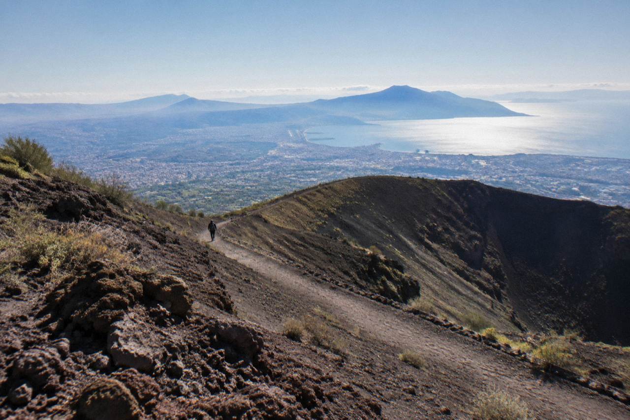The Gran Cono crater trail of Mount Vesuvius under a clear sky, with the Bay of Naples visible below