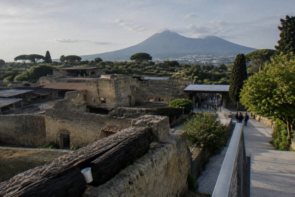 View across the excavated ruins of Herculaneum toward the slope of Vesuvius in soft light