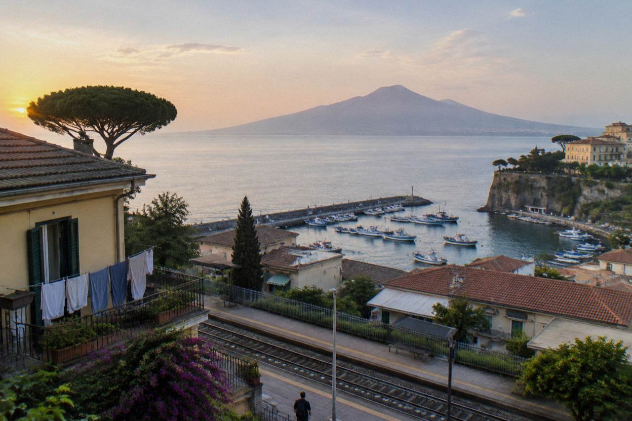 Sorrento rooftops and harbour with the shape of Mount Vesuvius across the bay in soft morning light