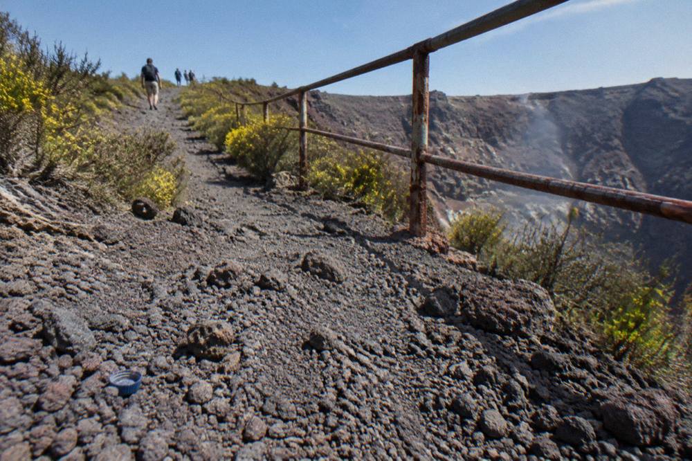 Ash slope path rising toward the rim of the Vesuvius crater under a clear sky