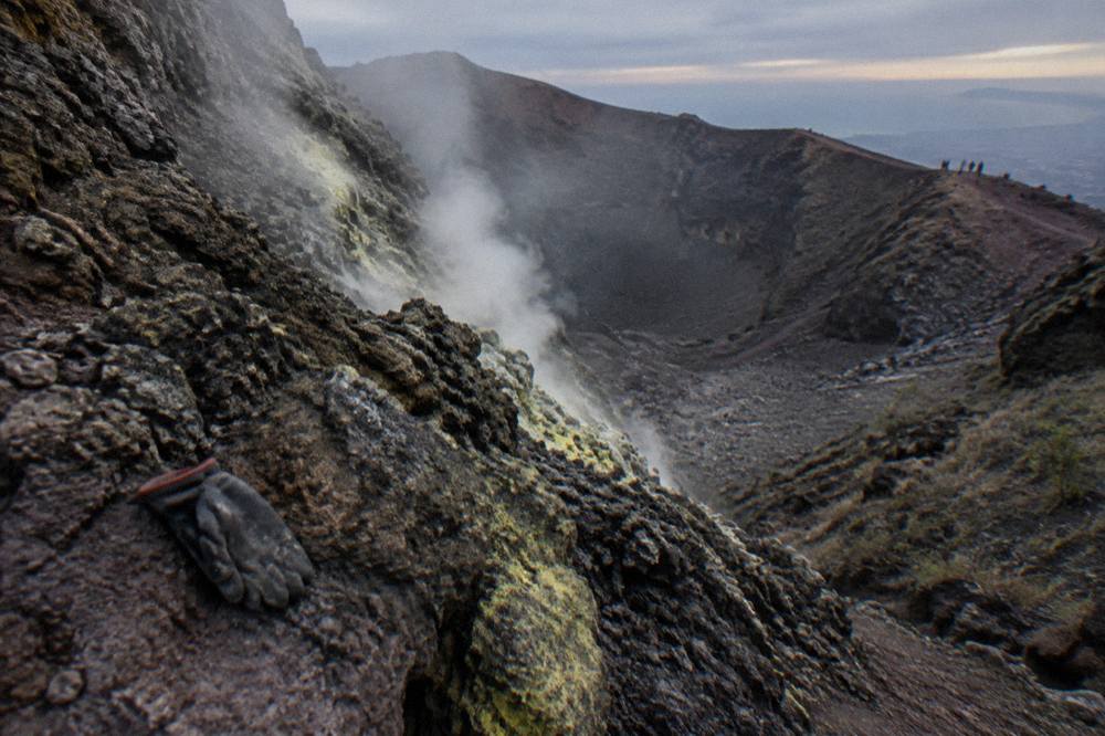 Steam vents on the inner wall of the Vesuvius crater with dark volcanic rock slopes