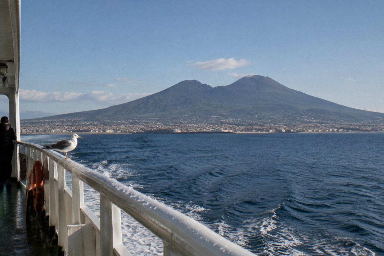 The Somma-Vesuvius volcanic massif rising above the Bay of Naples coastline under a clear sky