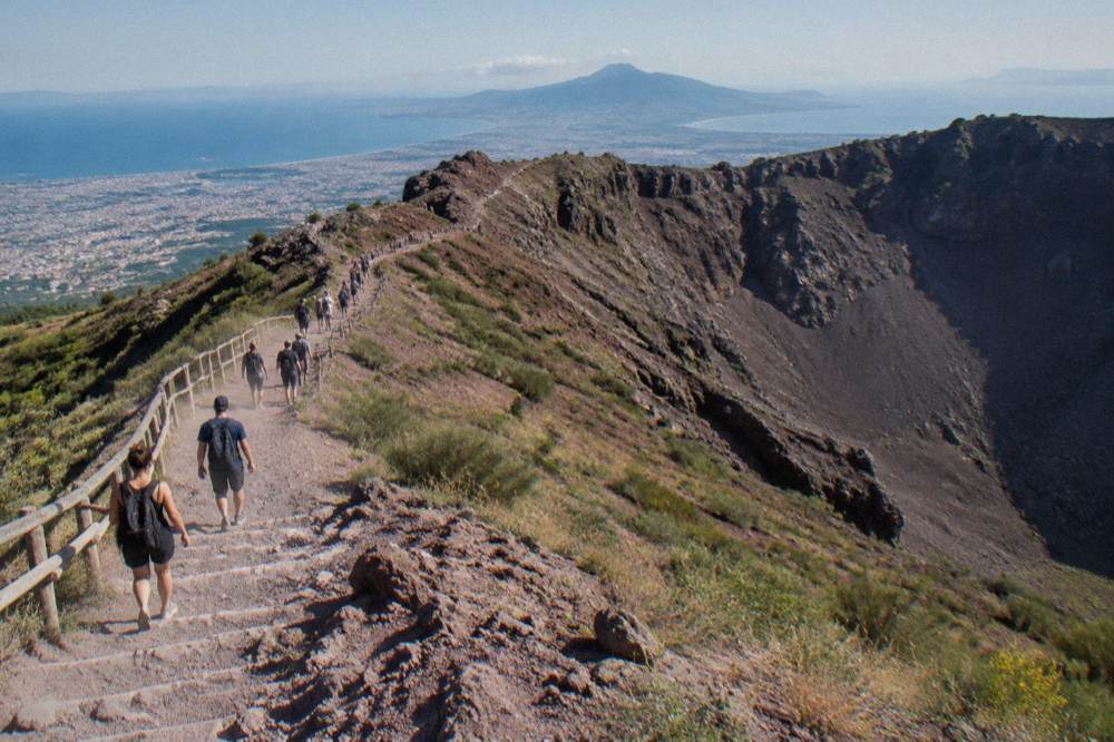 Volcanic trail winding up loose gravel slopes toward a ridge line