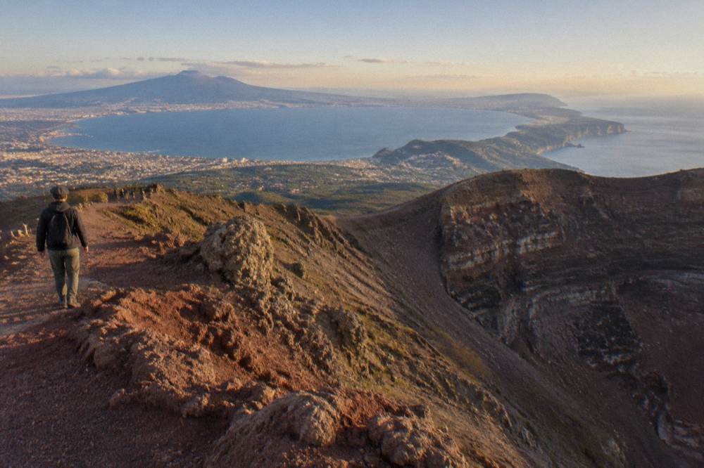 The crater rim of Mount Vesuvius in late afternoon light with the Bay of Naples and Sorrento peninsula below