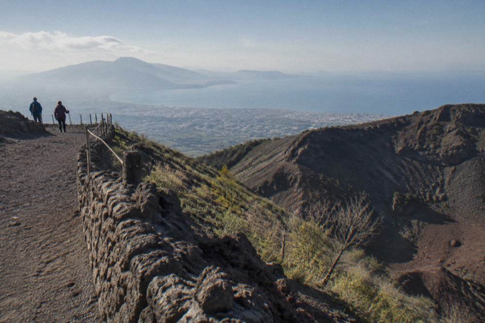 Walkers on the crater path with the Pompeii plain and the Bay of Naples spreading below