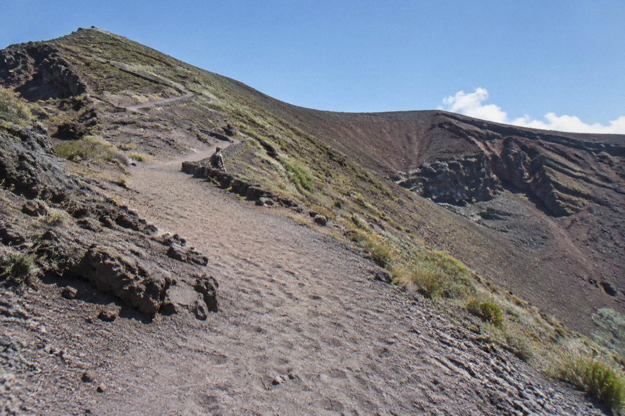 The gravel crater trail winding up the slope of Mount Vesuvius under a summer sky
