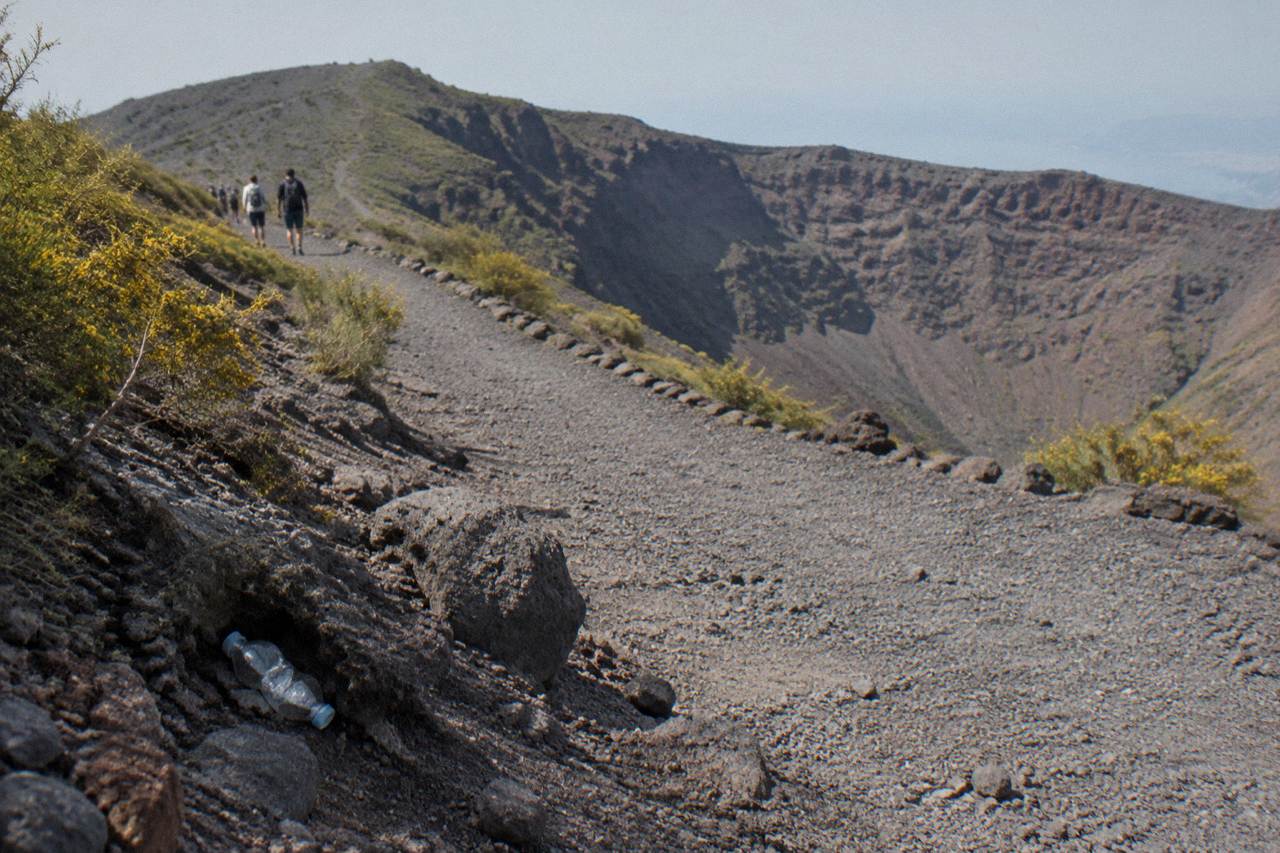 Wide gravel path climbing gently across the slopes of Mount Vesuvius with low scrub on both sides