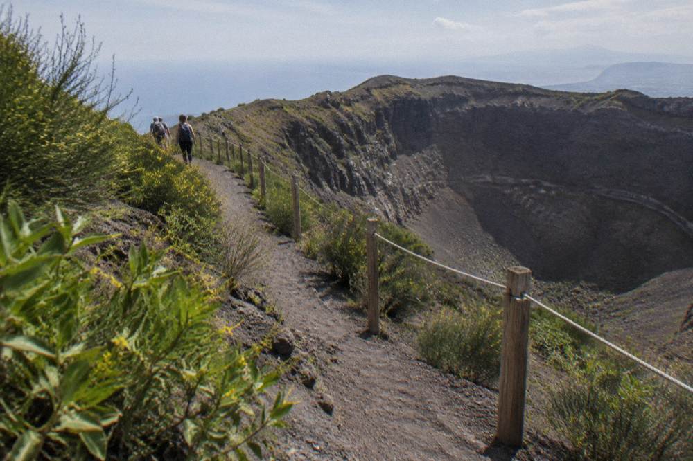 A narrow volcanic ash path climbing through low scrub toward the Vesuvius crater rim