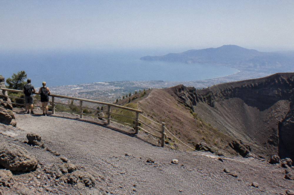Hikers on the crater rim viewpoint looking across the Bay of Naples toward Sorrento