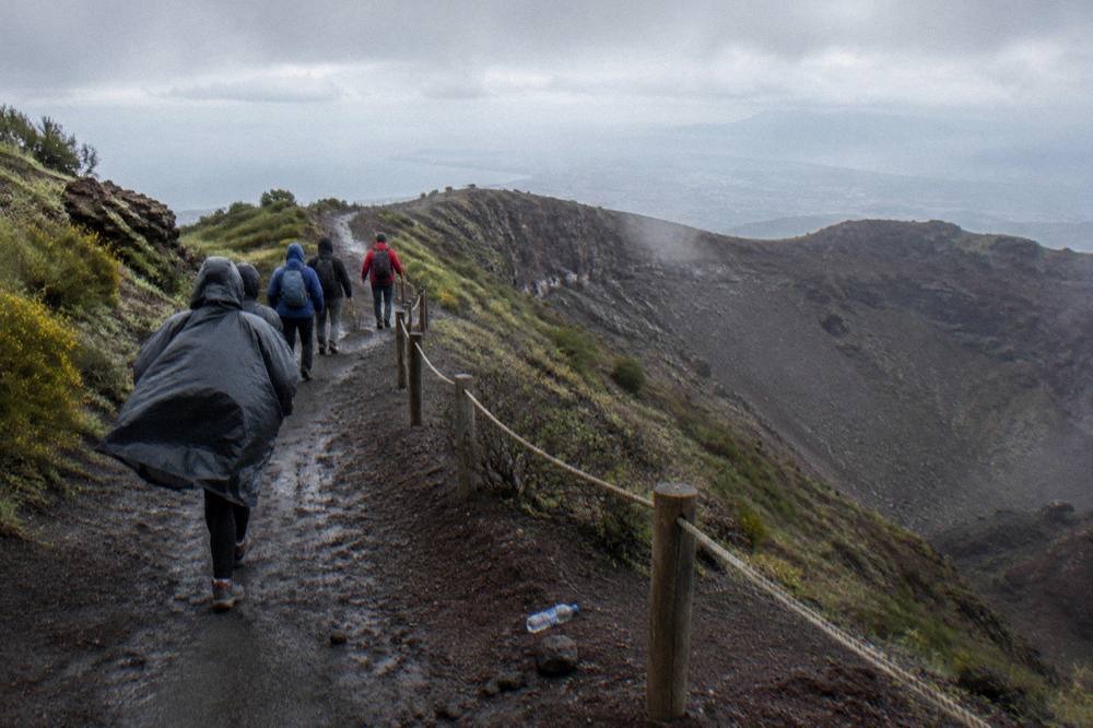 A small guided group walking the crater path with a volcanological guide