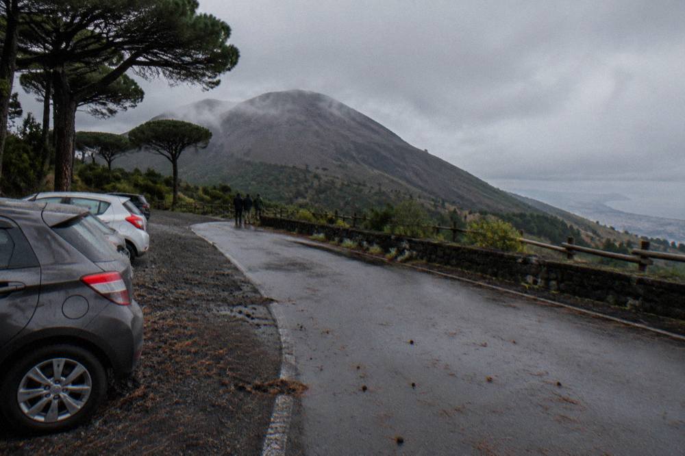 Vehicles parked along a provincial road on the slopes of Vesuvius in morning light