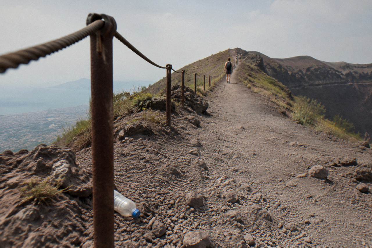 Dirt crater trail rising toward the rim of Mount Vesuvius under an open sky