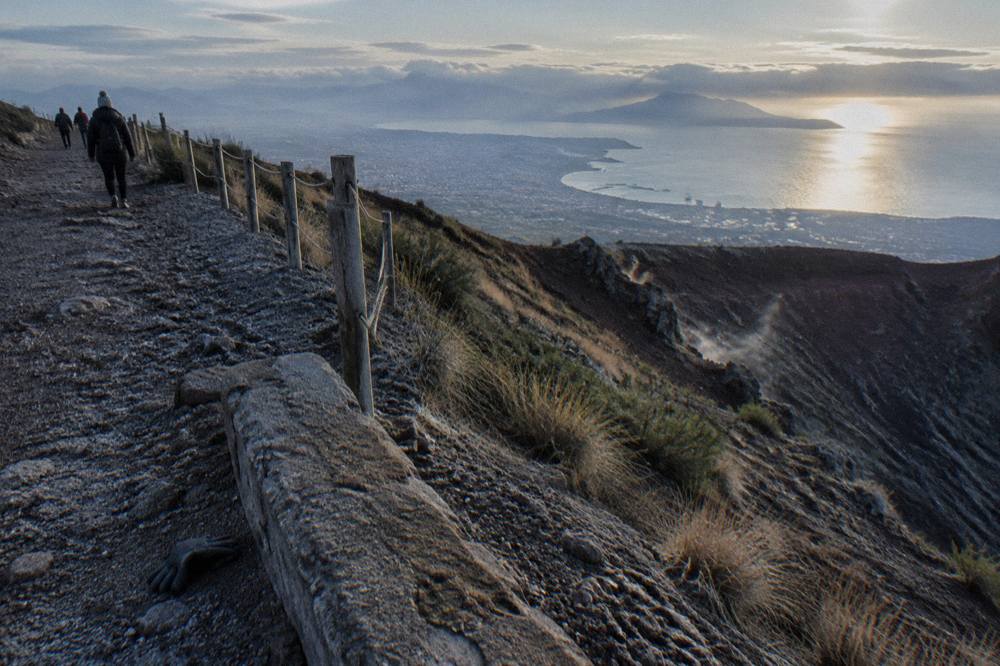 Vesuvius crater rim path with loose volcanic gravel and views across the Bay of Naples