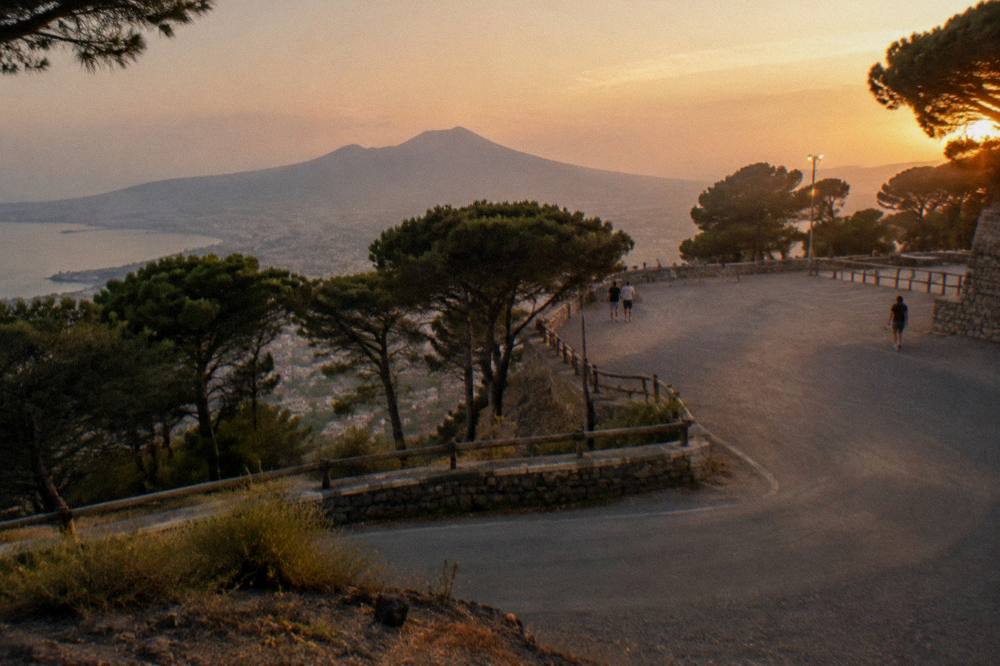 The switchback access road climbing the wooded flank of Vesuvius toward the Quota 800 parking area