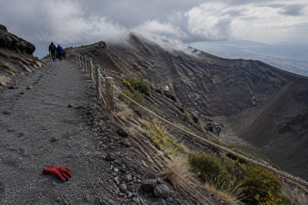 Vesuvius crater rim trail with wind-blown clouds moving over the summit ridge
