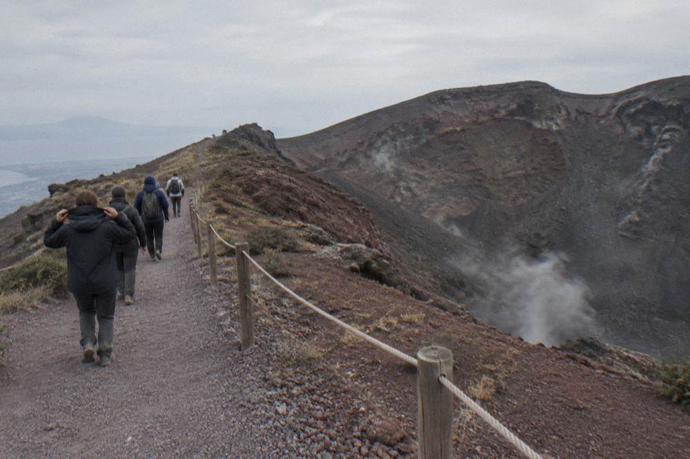 Tour group walking the crater ridge path of Vesuvius under a high overcast
