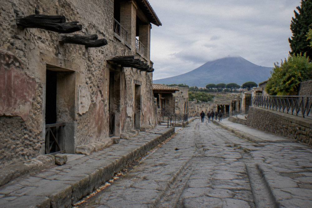 Ancient Roman stone street with worn cart ruts and ruined walls
