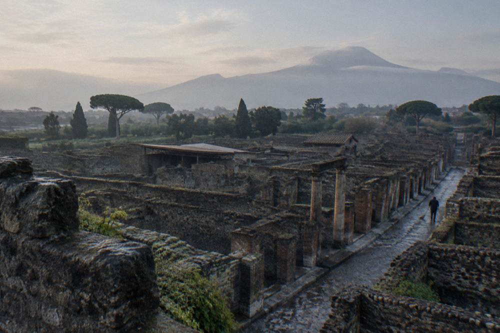 Wide view over excavated ruins with columns and distant hills