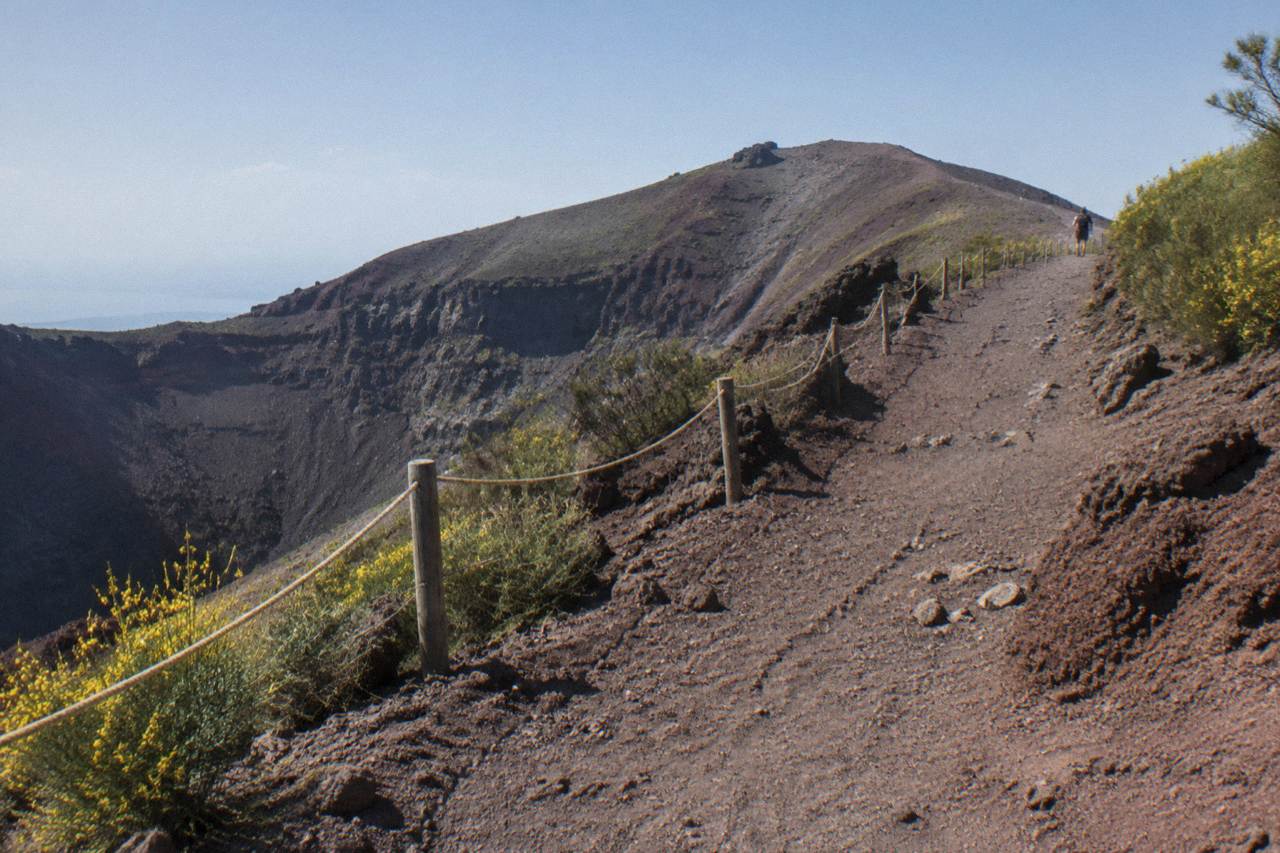 The dusty crater trail of Vesuvius rising through sparse volcanic ground under an open sky